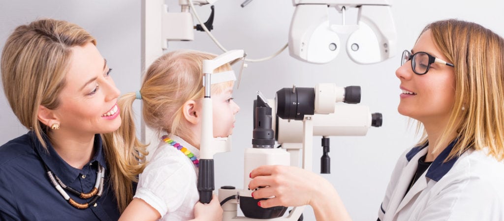 optometrist checking little child's vision